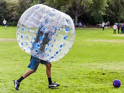 Person in aufblasbarem Bubble-Ball auf einer Wiese, ideal für Freizeitspaß und Bubble-Fußball, jetzt günstig und hochwertig online kaufen.